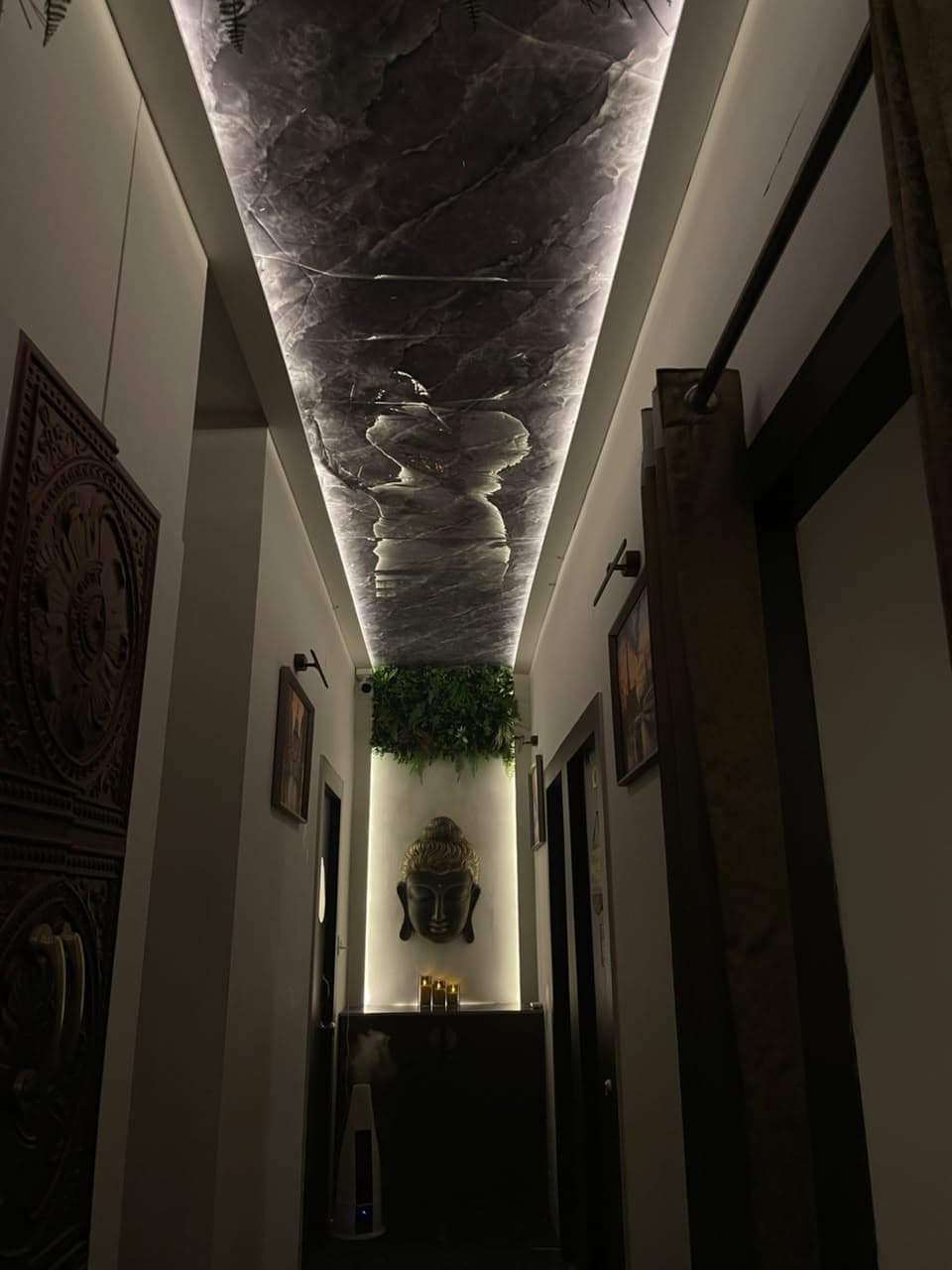 Spa corridor with backlit ceiling and Buddha sculpture at Senses Wellness Spa