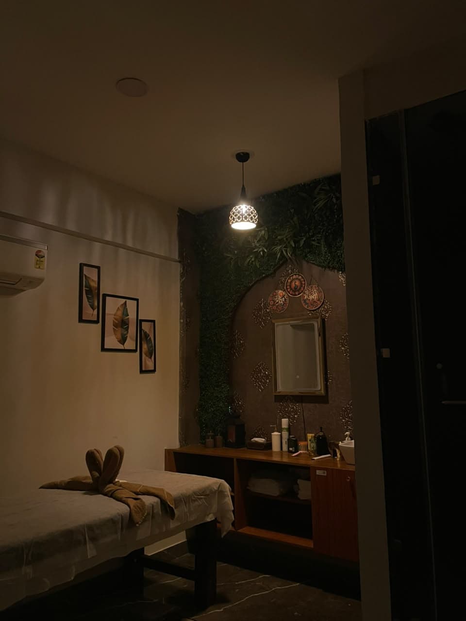 Single treatment room with wall art, mirror and warm pendant light